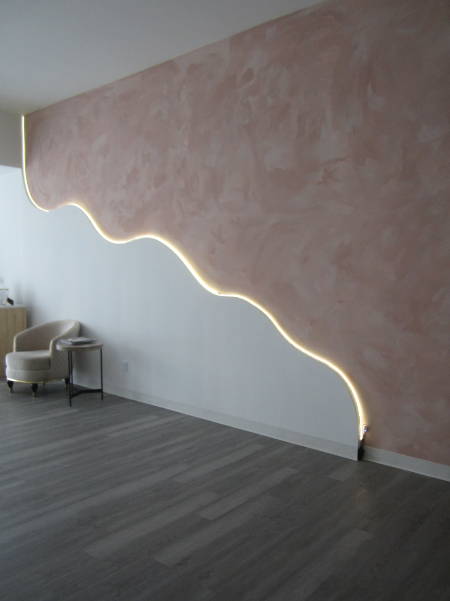 Blush pink accent wall with warm backlighting