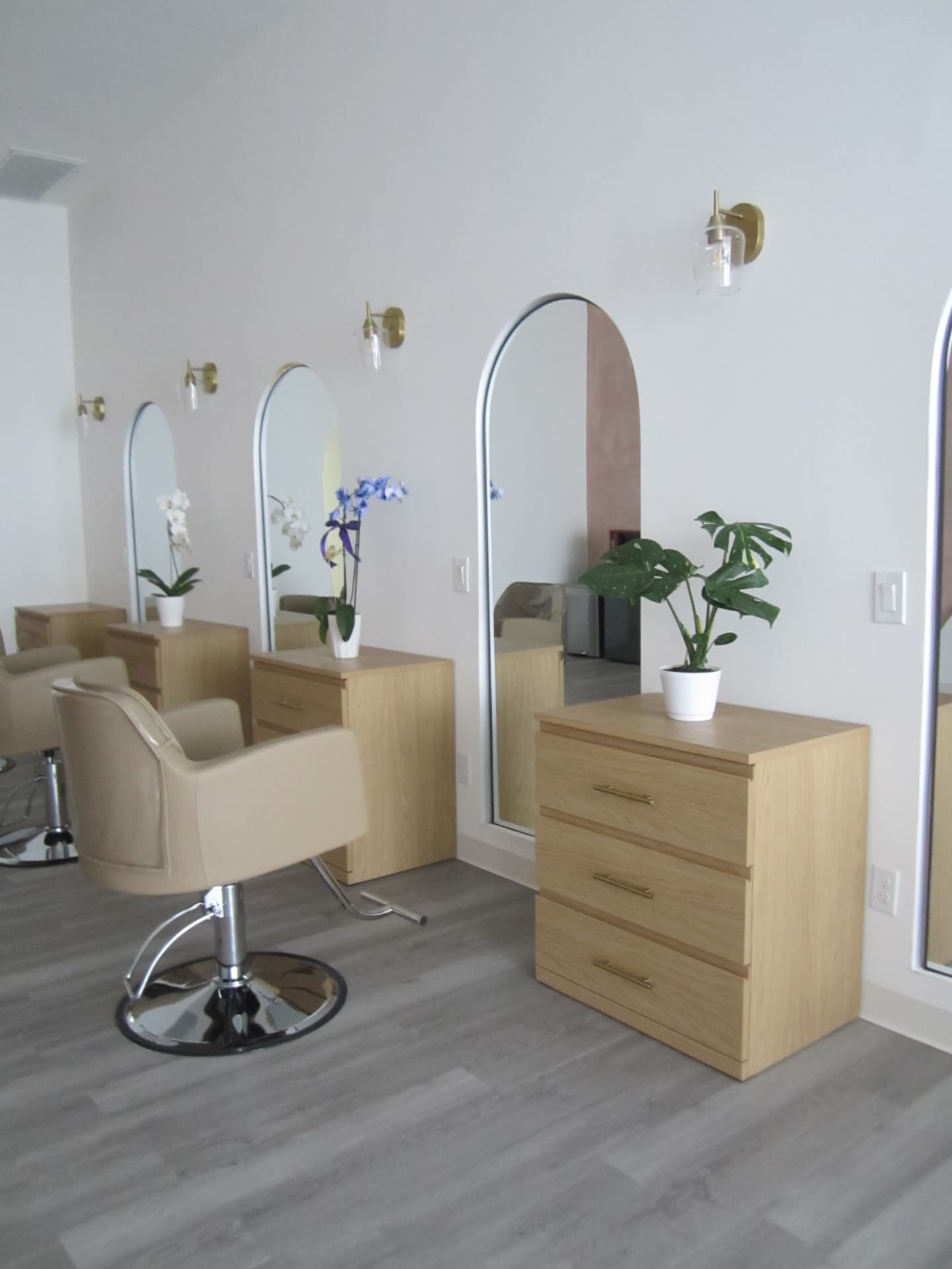 Salon styling station with arched mirror and beige chair